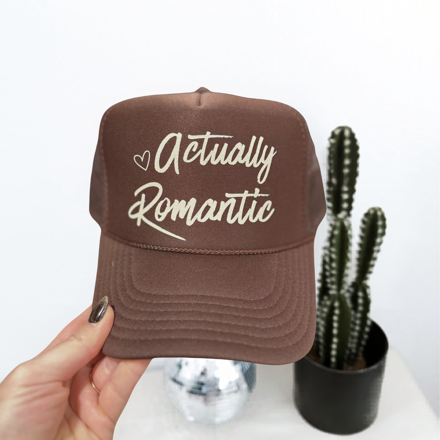 Actually Romantic chocolate brown trucker hat with cream script lettering and heart detail aesthetic cap